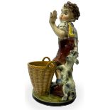 Pottery sculpture depicting child with dog and basket, early twentieth secolo.H cm 35. Defects in th