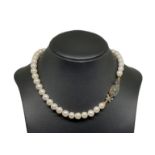 Pearl Necklace 42 cal. 11-11 ½ susta in gold and silver with central emerald and diamond small roses