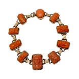 Bracelet in coral, with 11 miniatures depicting faces and floral decorations. Overall length of 19.5