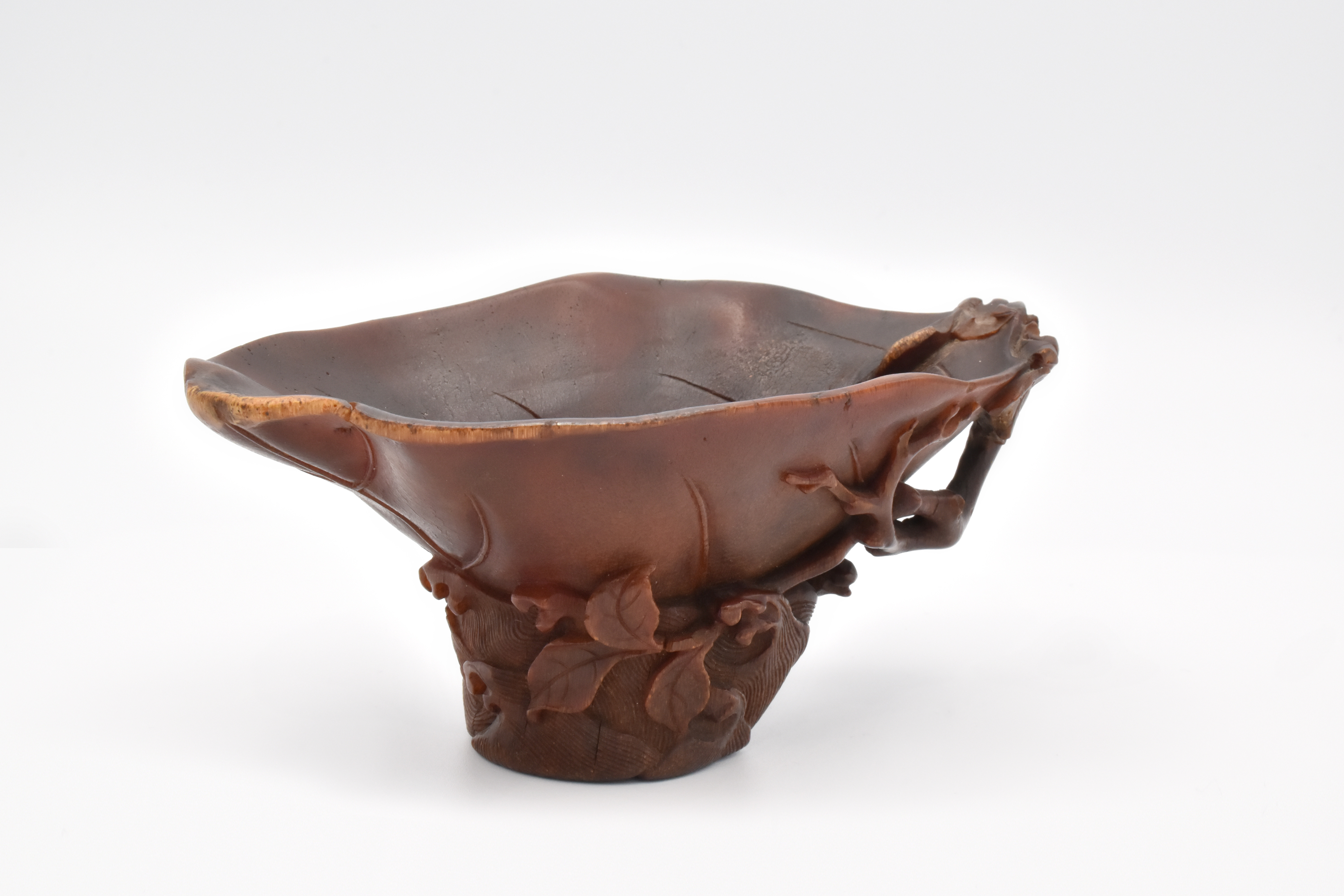A RARE CHINESE RHINOCEROS HORN ‘CAMELLIA LEAF’ LIBATION CUP, QING DYNASTY, 17TH CENTURY