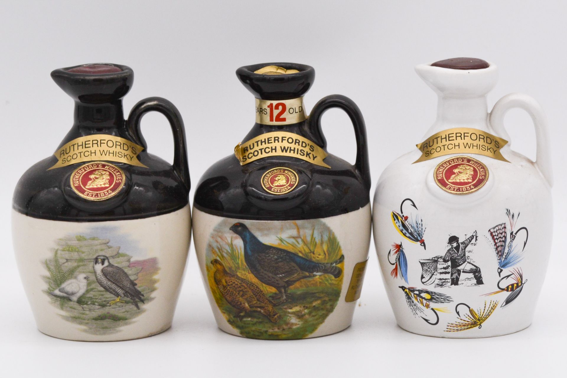 Four Rutherford's 12 year old ceramic decanters, and two others
