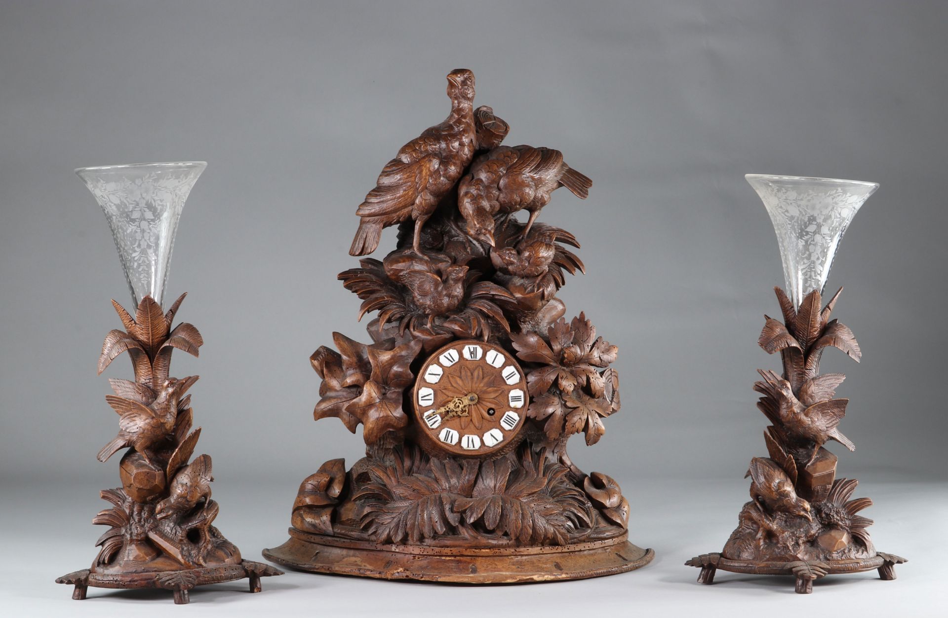 Black forest clock and its two Bohemian crystal vases. Germany, Switzerland. Late 19th century.