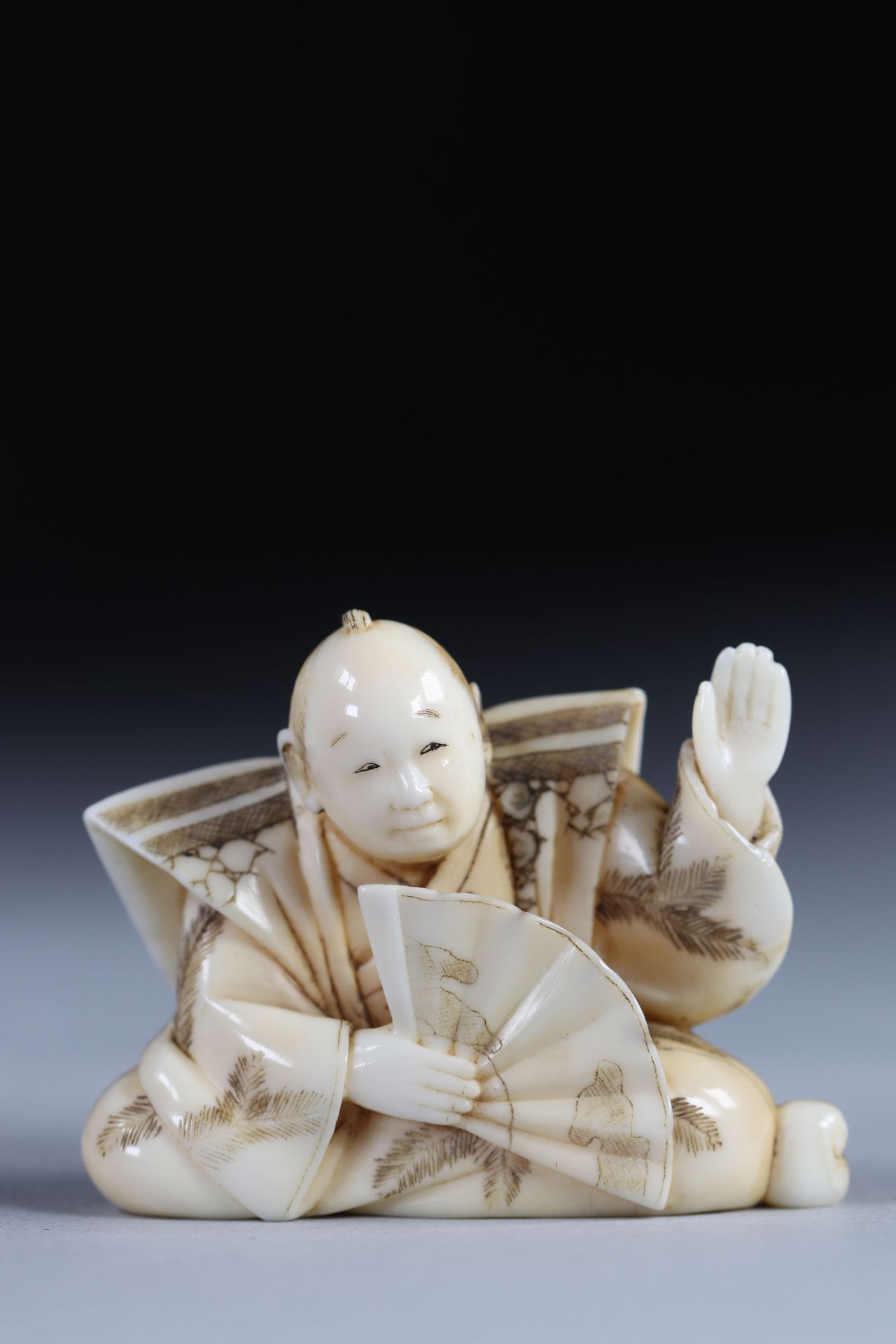 Netsuke carved - a character - a fan. Japan Meiji period around 1900