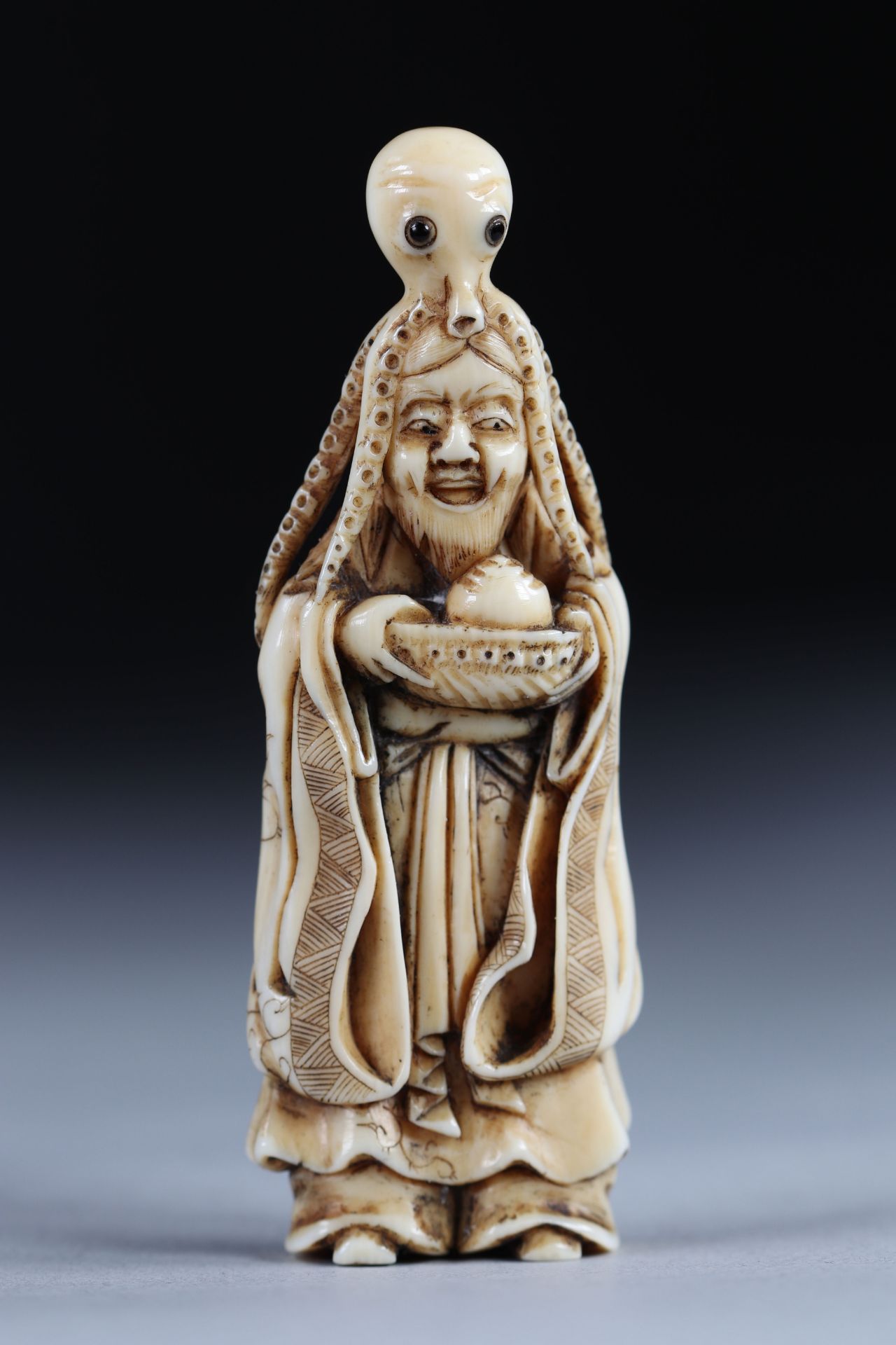 Netsuke carved - a woman wearing an octopus. Japan Meiji period around 1900