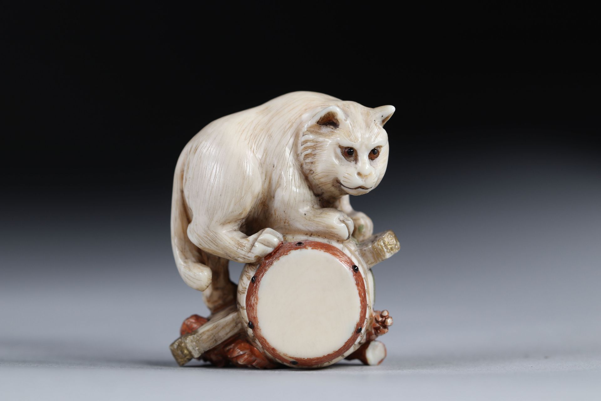 Netsuke carved - a cat on a drum. Japan early 20th century