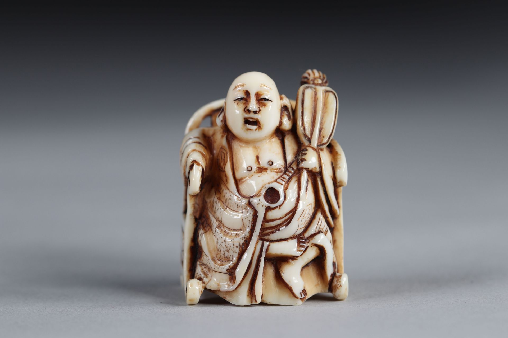 Netsuke carved - a Buddha seated on a throne. Japan Meiji period late 19th signature