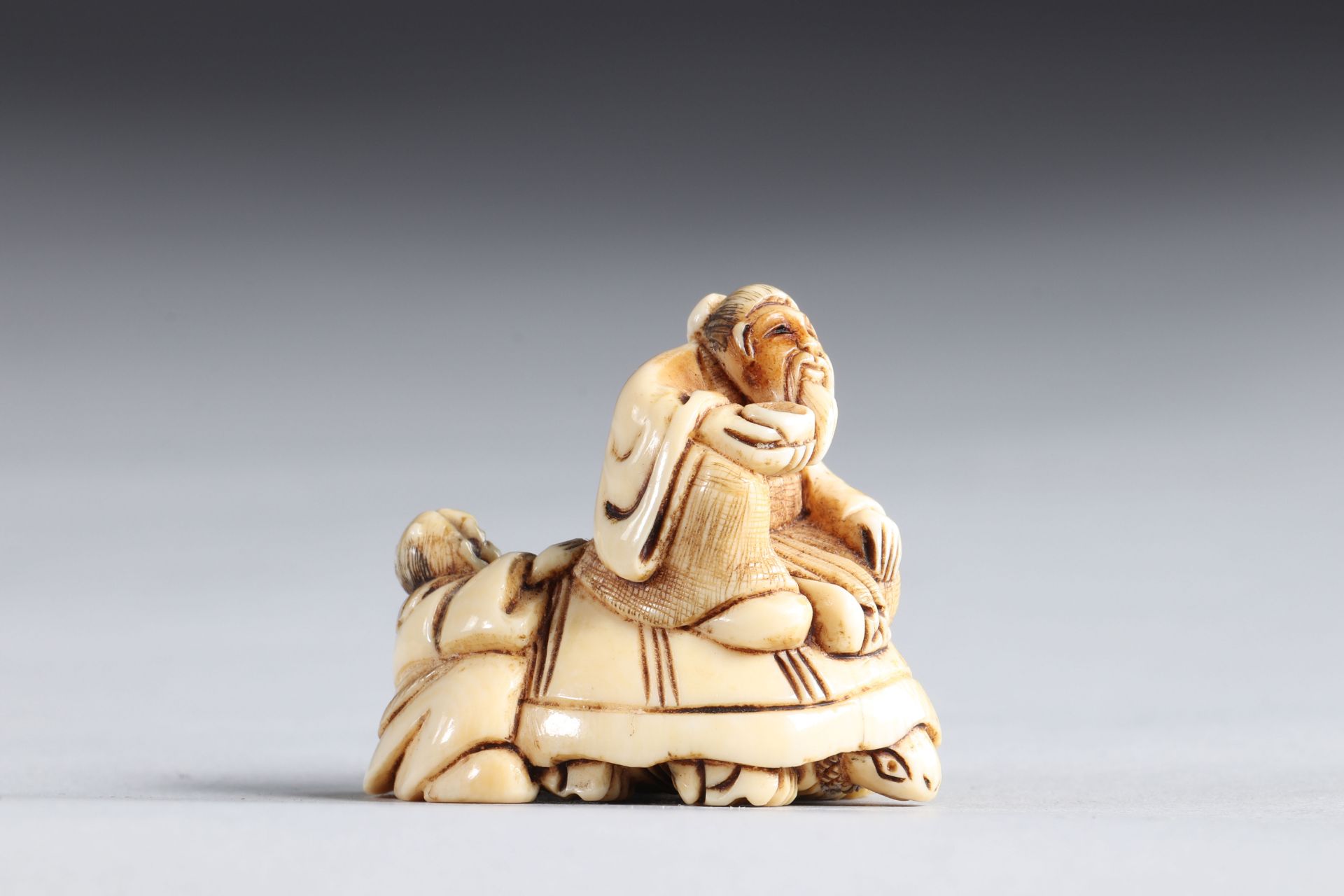 Netsuke carved - figures riding a turtle. Japan Meiji 19th century