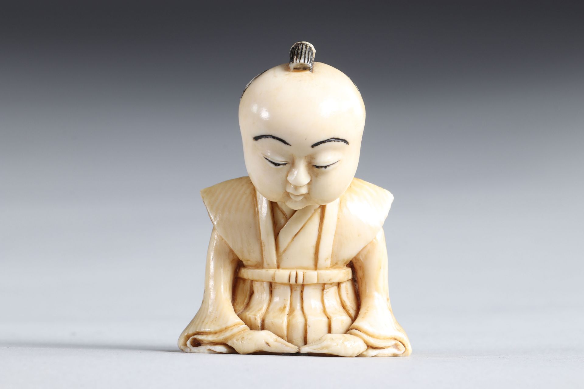 Netsuke carved - a seated figure. Japan Meiji 19th century