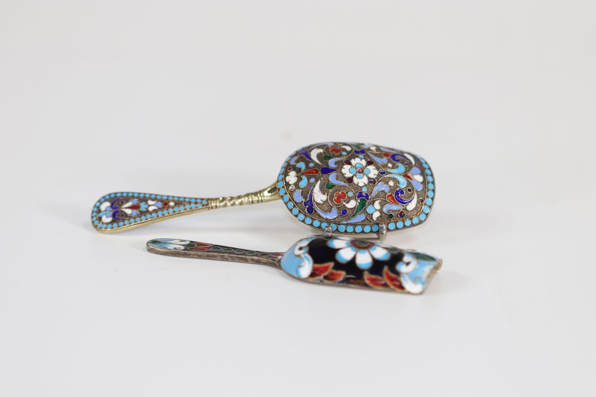 Lot of two enamelled silver tea scoops, Russia late 19th and mid-20th century.