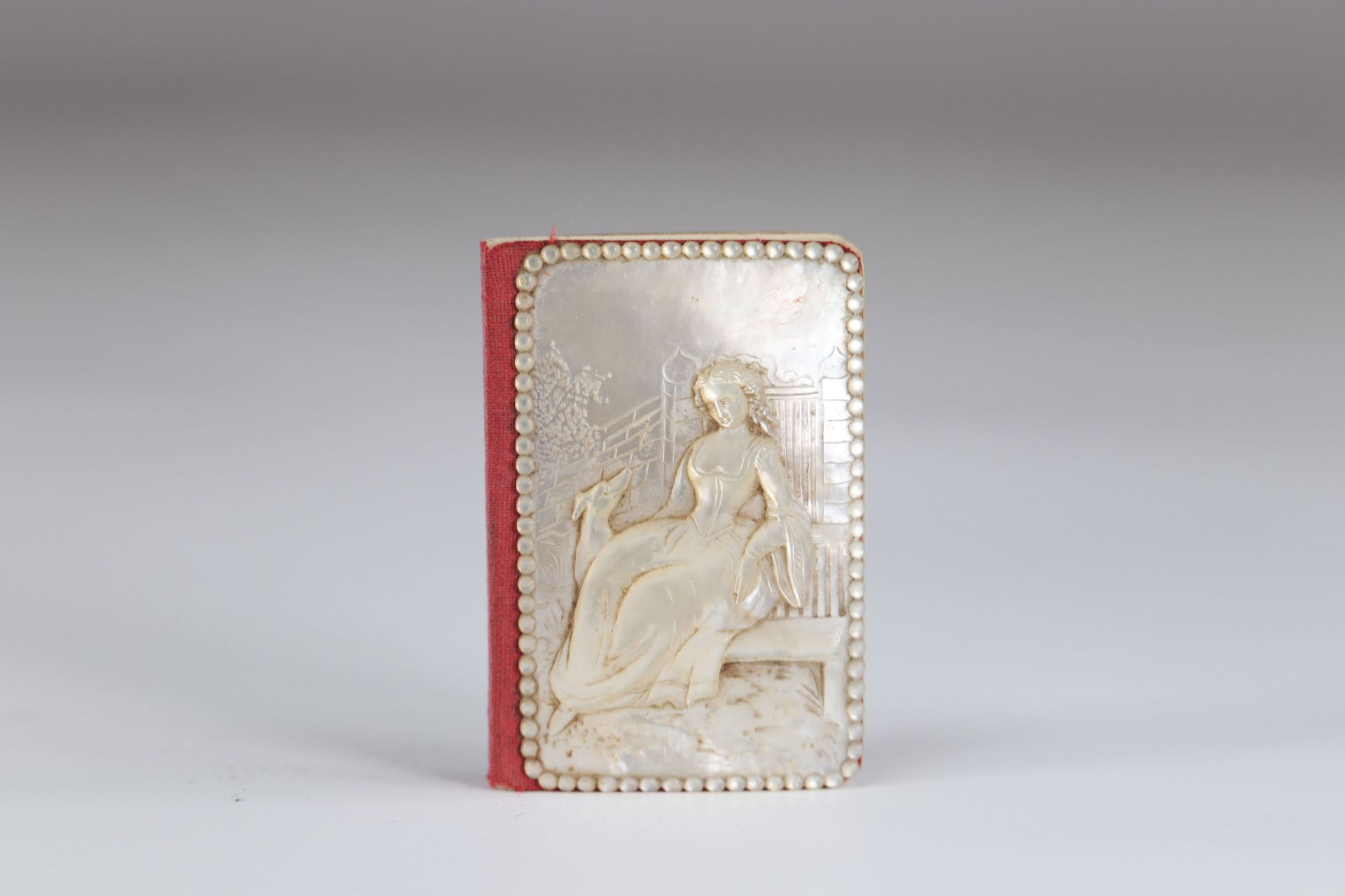 Carved mother-of-pearl ball book of a young woman with a greyhound