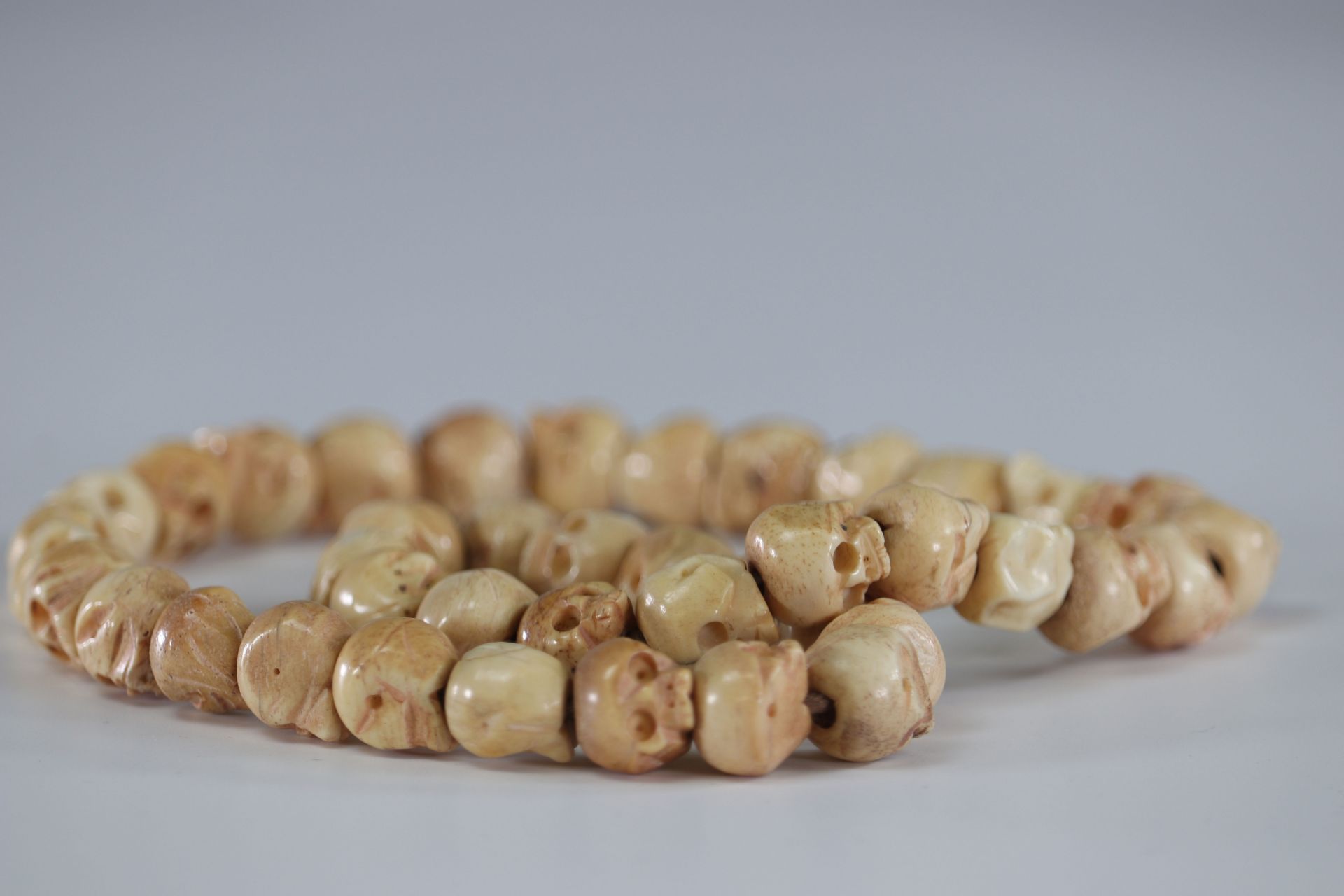 Necklace decorated with carved bone skull