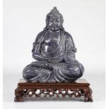 Stone Buddha on a wooden plinth