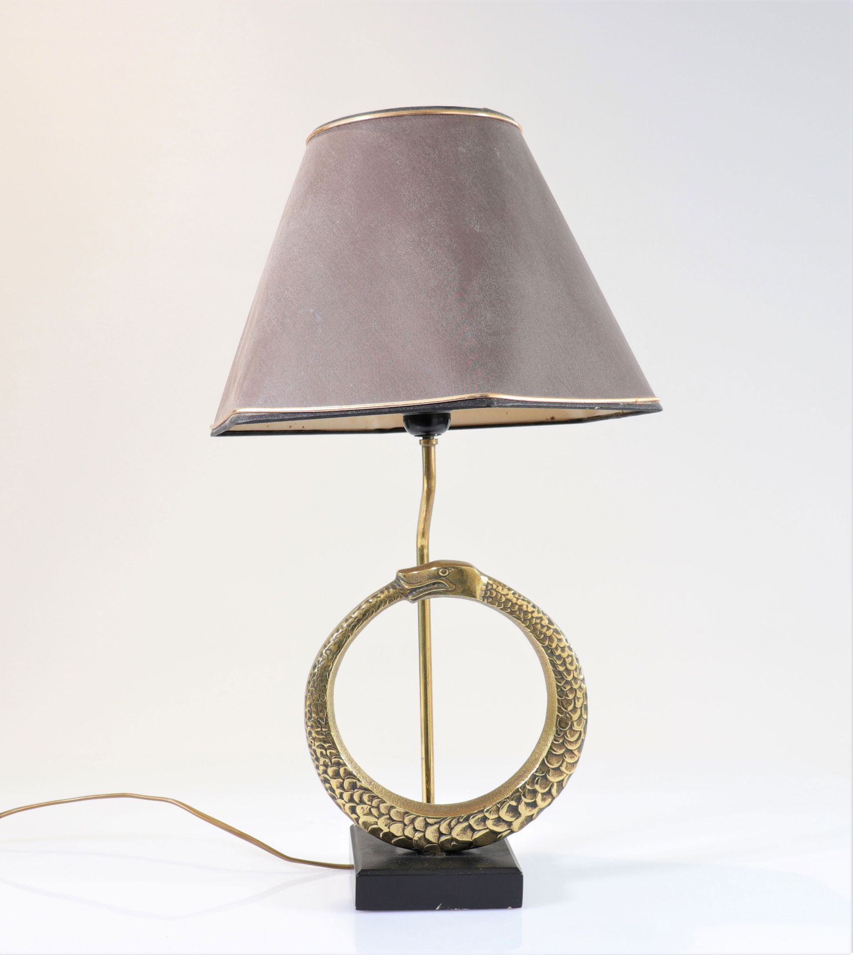 Vintage lamp decorated with a snake biting its tail in bronze