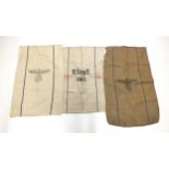 Three German Second World War grain sacks, the cloth sacks with eagle atop a swastika, variously