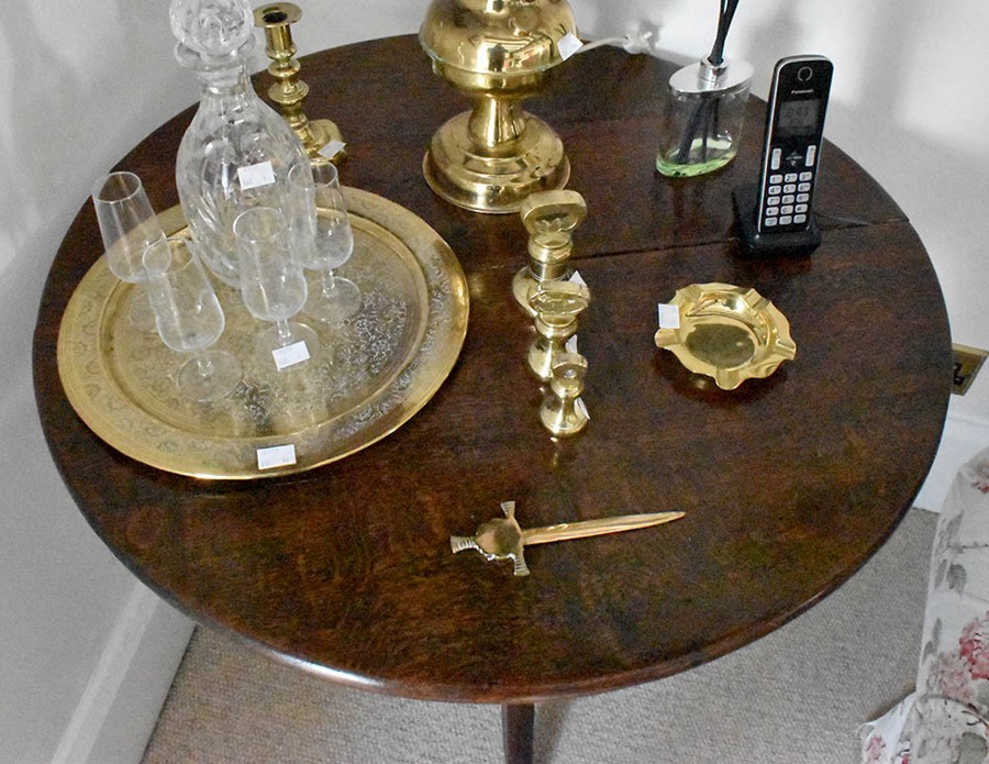 A George III oak tilt top table, circa 1780, circular top on a turned column raised on acanthus trio