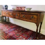 A George III elm dresser, circa 1780, fluted edge top in a rectangular form on a moulded cornice,