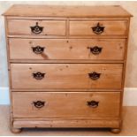 A late Victorian pine chest of drawers, slight oversailing moulded edge top, above two and three