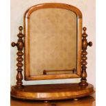 A late Victorian mahogany dressing swing mirror, with Hispanic bobbins supports, oval base raised on