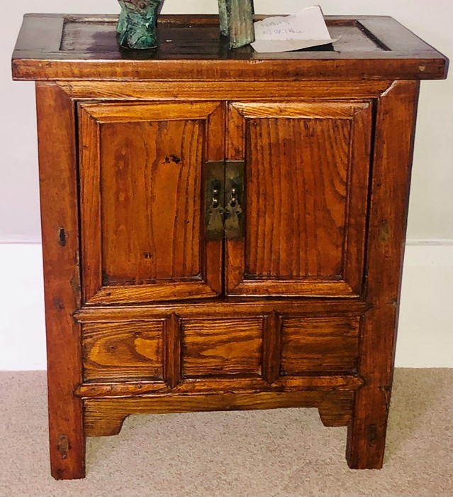 A Chinese elm collectors cabinet, moulded oversailing top, above two panel cupboards over three