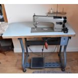 An industrial sewing machine by Consew on a heavy duty table.