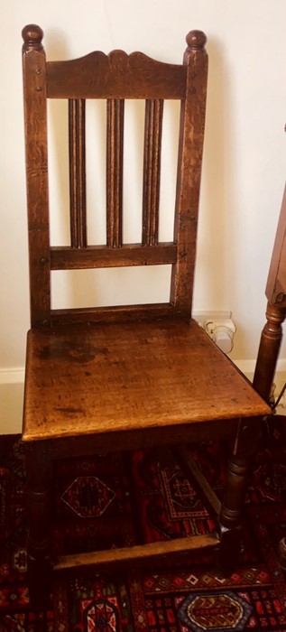 A George III oak hall chair, globe finials, rectangular high back, serpentine rail over fluted