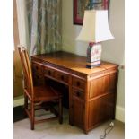 A Chinese hardwood kneehole desk, rectangular top above moulded cornice over an arrangement of mould