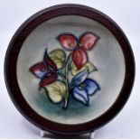 Moorcroft: A Walter Moorcroft 'Bougainvillea' pattern coaster on a light green wash ground in a