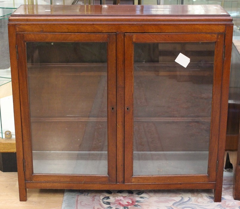 An early 20th Century mahogany glazed bookcase, circa 1910, fitted with two doors enclosing shelves,