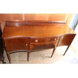 An early 20th Century Georgian style mahogany sideboard, of serpentine form, fitted with a central