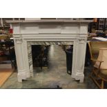 A large white painted wooden and marble embellished Classical style fire surround, complete with