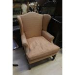 A George III style wing chair, probably early 20th Century, raised on block feet, salmon pink