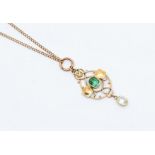 An Arts Nouveau 15ct gold green tourmaline pendant, comprising a central cushion cut tourmaline