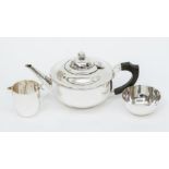 A George V plain circular silver matched three piece tea service comprising teapot, sugar bowl and