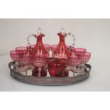A collection of assorted cranberry glass, comprising a pair of Victorian decanters a bowl and cover,