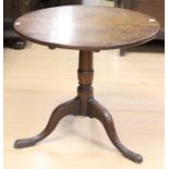 A George III oak tilt top tripod table, circa 1770, the three plank circular top, raised on a turned