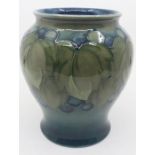 A William Moorcroft leaf and berry pattern baluster vase, in tones of green and blue, impressed