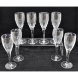 Fifteen champagne flutes, seven of which have blue stems