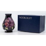 A Moorcroft 'Clematis' pattern navy ground vase, baluster form, tube lined decoration, stamped to