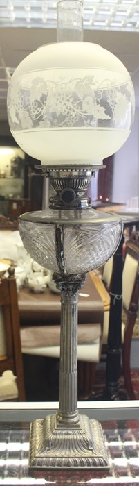 A late 19th Century plated oil lamp with etched glass shades above facet cut reservoir, the