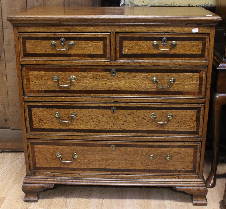 A George III oak and mahogany cross-banded chest of drawers, circa 1790, comprising two short over