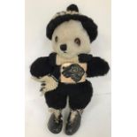 A 1960's black and white panda with a 1960's Derby County badge, wearing boots and scarf