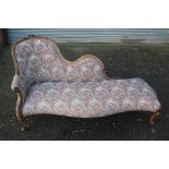 A Victorian walnut chaise longue, carved crest rail, shaped back, upholstered back and seat,