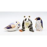 Three Royal Crown Derby paperweights including a giant panda, penguin and owl with silver stoppers