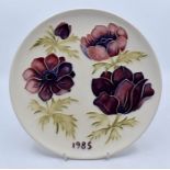 Moorcroft Pottery: A Moorcroft 'Anemone' pattern year plate for 1985. Diameter approx 22cm.