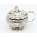 A George IV large circular mustard pot and cover, bulbous body and cover chased and engraved with