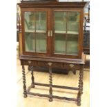 A William and Mary period or later walnut cabinet on stand, fitted with two glazed doors enclosing a