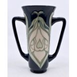 Moorcroft Pottery: A Moorcroft Collectors Club twin handled 'Snowdrop' pattern vase designed by