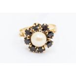 An 18ct gold pearl and sapphire set cluster, comprising a central cultured pearl  with a border of