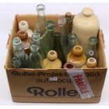 A collection of vintage early 20th Century glass and stone ware bottles including foot warmer