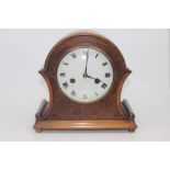 An early 20th Century walnut eight day mantel clock, white enamelled dial and Roman numerals